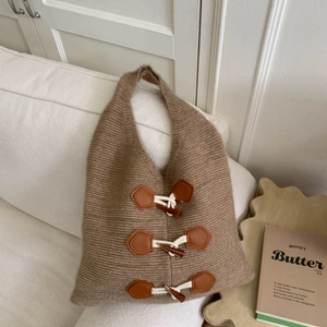 Detail of knit shoulder bag with classic horn toggle buttons and thick textured yarn