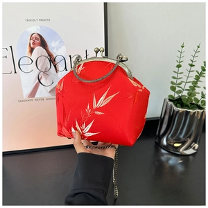 Detail of red silk shell bag with white bamboo leaf patterns and vintage metal clasp