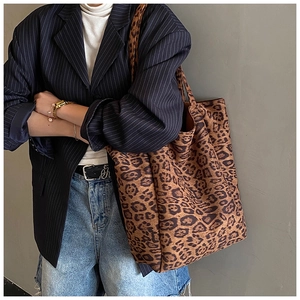Detailed view of large leopard print tote bag with soft suede texture on a model