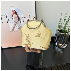 Detail of champagne silk handbag with bamboo embroidery and vintage bronze chain