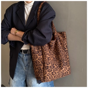 Detail view of large leopard print tote bag with suede texture shown on a model