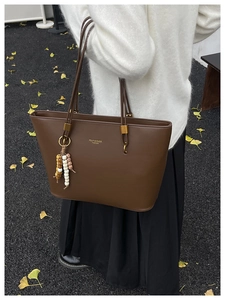 Detail of vintage dark brown faux leather tote bag with FDJY text and beaded tassel