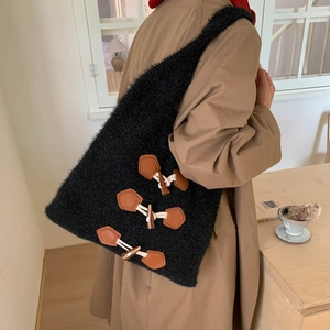 Detail of black faux fur tote bag with vintage toggle button closures and soft texture