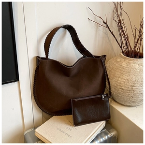 Detail of a large brown hobo bag with woven edges and matching zipper pouch set