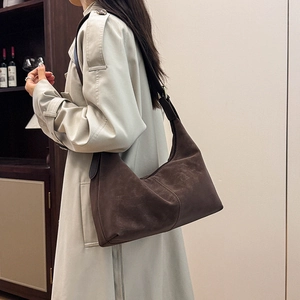 Detail view of coffee brown crescent bag in retro matte leather with vertical stitching
