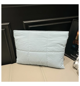 Detail of light blue quilted waterproof puffer laptop sleeve with magnetic closure