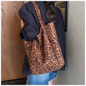 Detail of soft leopard print tote bag texture and wide canvas shoulder strap on a model