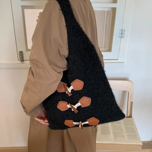 Detail of black faux fur tote bag with toggle horn buttons and leather patches