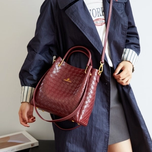 Dettaglio della trama in pelle intrecciata bordeaux e fibbia in metallo dorato borsa