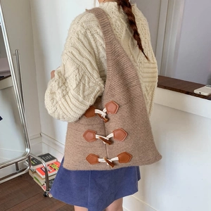 Detail of brown chunky knit tote bag featuring triple toggle buttons and textured fabric