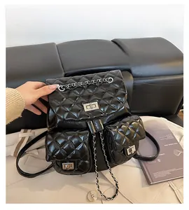 Detail of black quilted leather backpack featuring silver chain straps and turn-lock