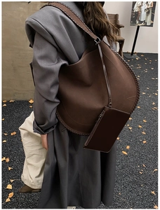 Detail view of dark brown oversized tote bag with thick woven stitching and small pouch