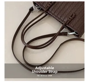 Détail du sac seau tressé marron foncé avec bandoulière en cuir réglable et métal