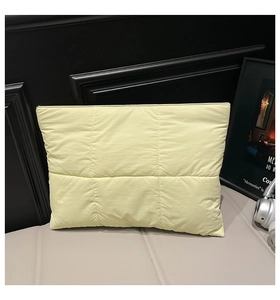 Detailed view of the quilted nylon tote bag with square stitching in light yellow finish