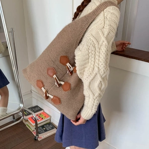 Brown knitted tote bag featuring faux leather horn buckles and thick wool material texture