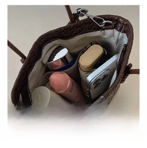 Vue intérieure montrant la grande capacité du sac cabas tressé avec objets divers