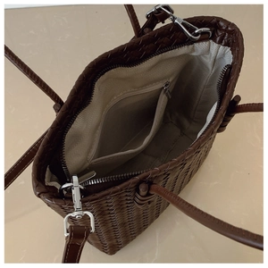 Détails de l'intérieur du sac tressé montrant la doublure chevron et poche zippée