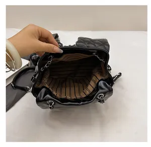 Detailed interior view showing striped lining and metal chain of the quilted backpack