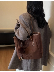 Sac fourre-tout en daim marron avec relief et pompon en fourrure sur modèle en blazer