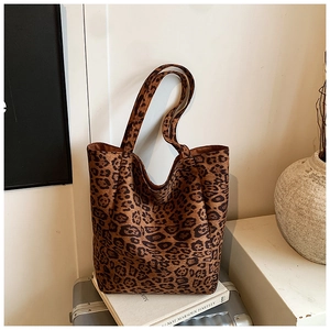 Detail of leopard print tote bag with plush suede texture on a white decorative setting