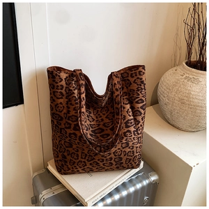 Close-up of leopard print tote bag texture and handles on luggage with a book