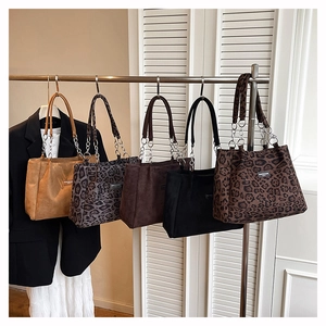 Détail de sacs fourre-tout léopard avec bandoulières en chaîne en diverses teintes d'automne