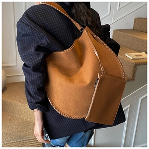 Detail of camel suede tote bag with woven edge and matching small pouch for commuting