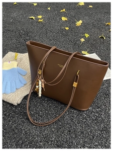 Close-up of a dark brown large tote bag with autumn leaf and knitwear decor