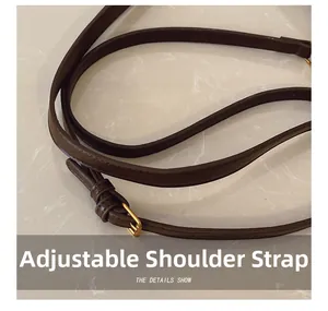 Close-up of adjustable dark brown leather shoulder strap with golden metal buckle hardware