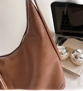 Detail of caramel leather shoulder bag with zipper in a modern lifestyle city setting
