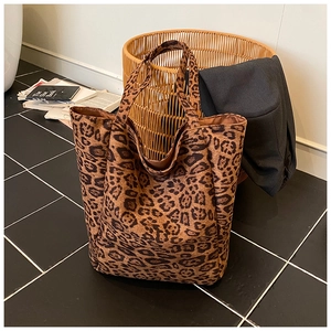 Macro shot of large leopard print tote bag fabric and its minimalist wide shoulder straps