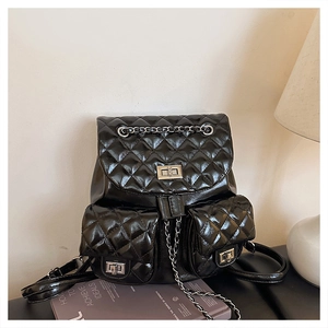 Detail of black quilted leather backpack with silver turn-lock and chain strap