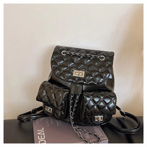 Close-up of black quilted leather backpack featuring silver twist locks and chain details