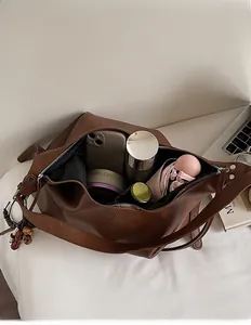 Macro shot of large capacity dark brown leather tote bag showing spacious inner compartment