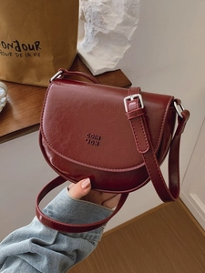 Sacoche selle chic en cuir verni bordeaux avec boucles argentées et fermeture à rabat