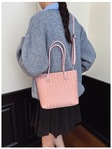 Gros plan sur le sac cabas tressé rose montrant la texture et la bandoulière