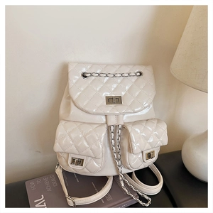 Close-up of beige quilted backpack featuring dual front pockets with metal twist locks