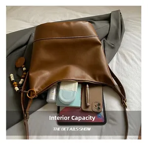 Detailed top view of brown leather tote showing large internal capacity and accessories