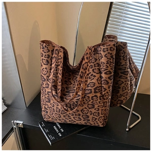Detailed view of spacious leopard print tote bag with wide shoulder straps in studio
