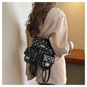 Close-up of quilted black backpack featuring silver twist locks and chain straps