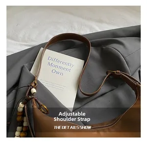 Adjustable leather shoulder strap with bronze buckle on vintage brown crossbody bag