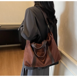 Detail of red-brown suede tote bag with contrast dark brown leather shoulder straps
