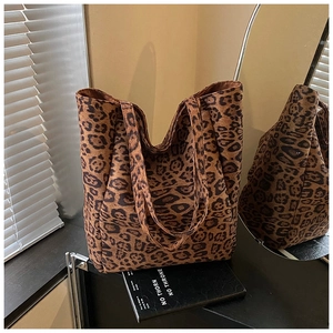 Chic leopard print tote bag with soft texture displayed on a stand in a stylish room
