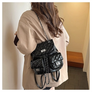Detail of quilted glossy PU leather backpack with silver chain straps and turn-lock pockets