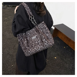 Detail of leopard print tote bag featuring metallic rings and soft plush fabric texture