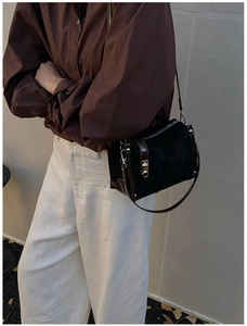Detail of vintage bicolor crossbody bag with silver metal turn-lock and suede texture