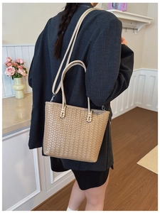 Sac fourre-tout en cuir tressé kaki avec bandoulière porté par un mannequin