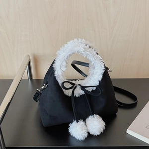 Détail du sac bandoulière en suédine avec bordure en fausse fourrure et pompons décoratifs