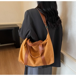 Detail of ginger suede tote bag with leather straps worn by model in casual setting
