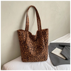 Detailed view of the leopard print suede texture and long shoulder strap on the large tote bag